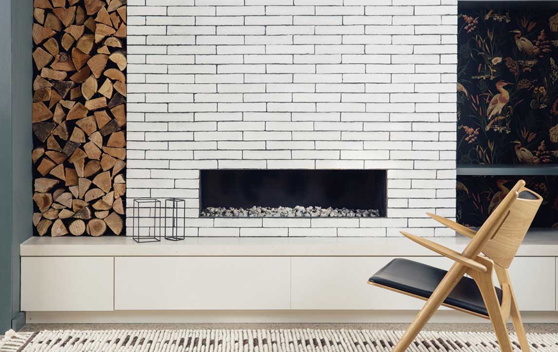 Chair sitting on rug in front of fireplace