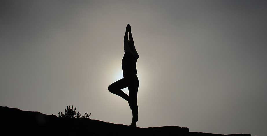 Woman doing yoga at sunrise